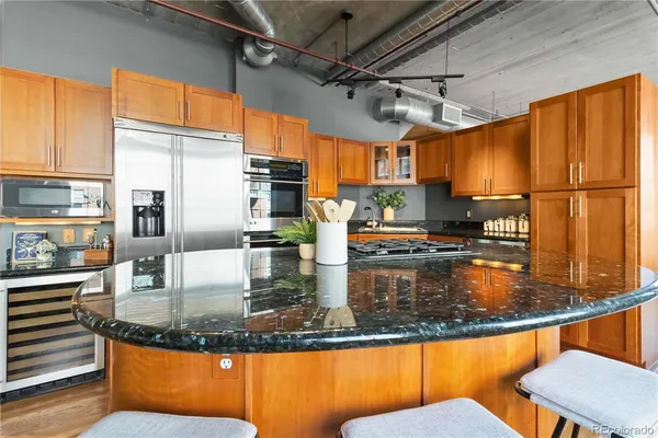 a kitchen with stainless steel appliances granite countertop a sink window and cabinets