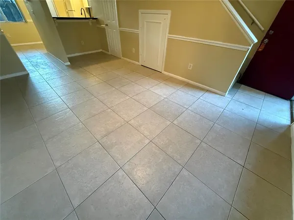 a view of a livingroom with kitchen and window