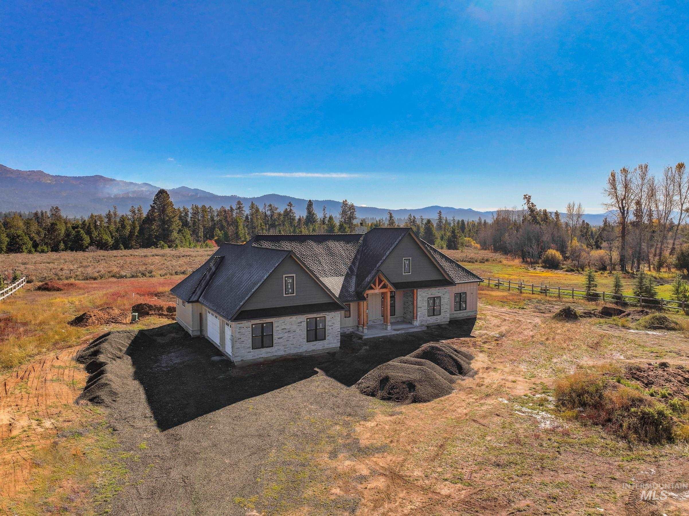 13910 Sky View Court, Unit 8 McCall, ID 83638 - Photo 20 of 40 View of front facade featuring a view of rural / pastoral area, a garage, a mountain view, and dirt driveway