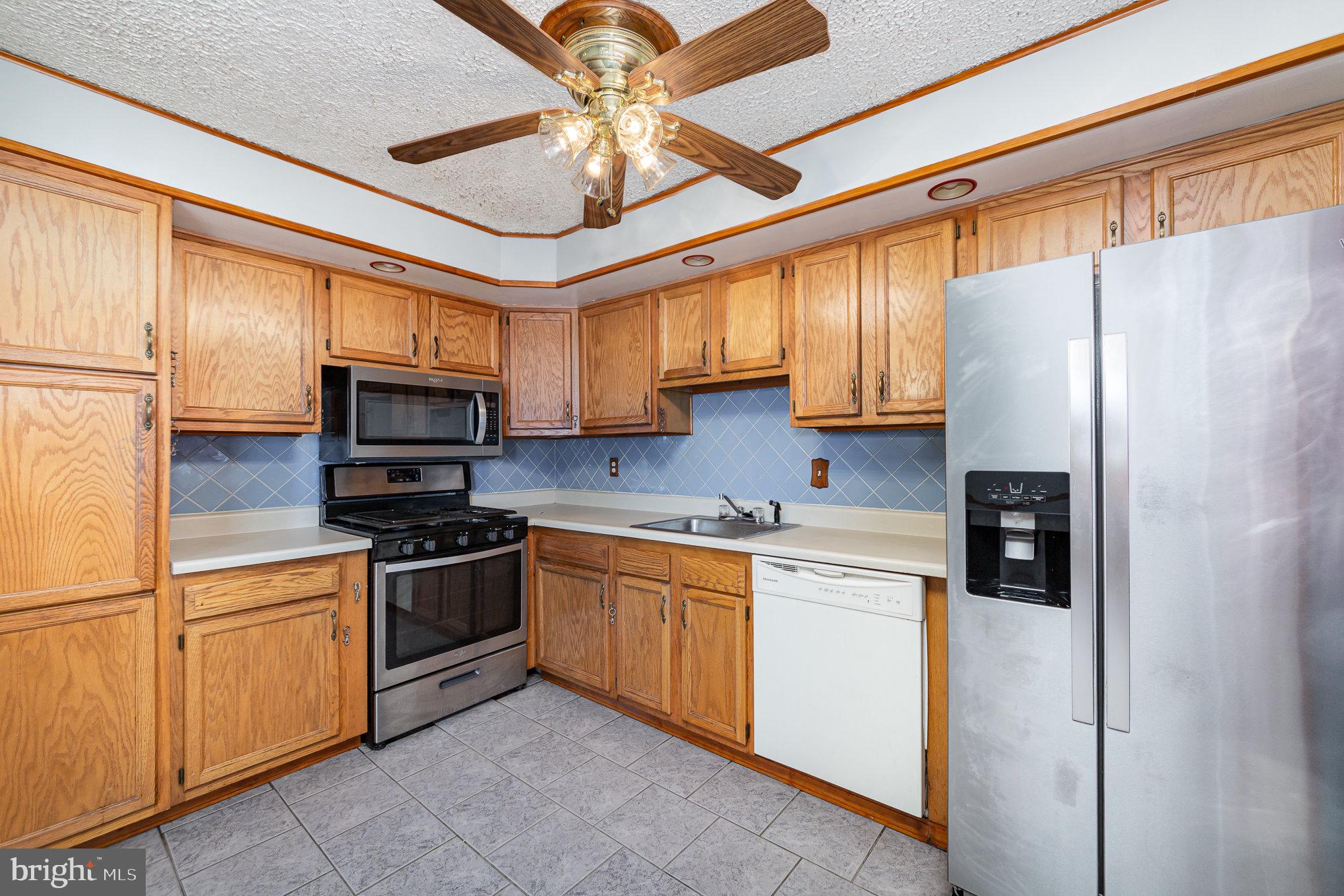 8226 North Boundary Road Baltimore, MD 21222 - Photo 14 of 37 a kitchen with stainless steel appliances granite countertop a refrigerator a stove microwave and sink