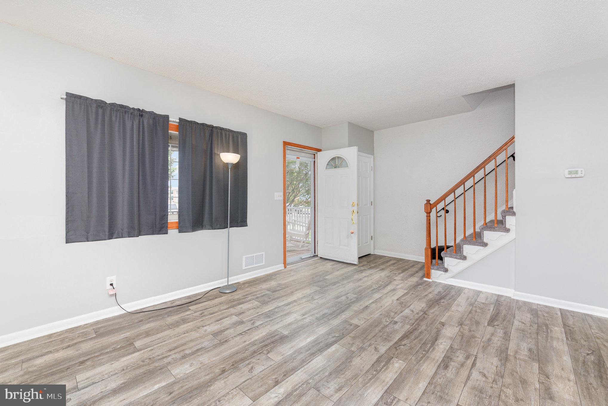 8226 North Boundary Road Baltimore, MD 21222 - Photo 5 of 37 a view of an empty room with stairs and a window