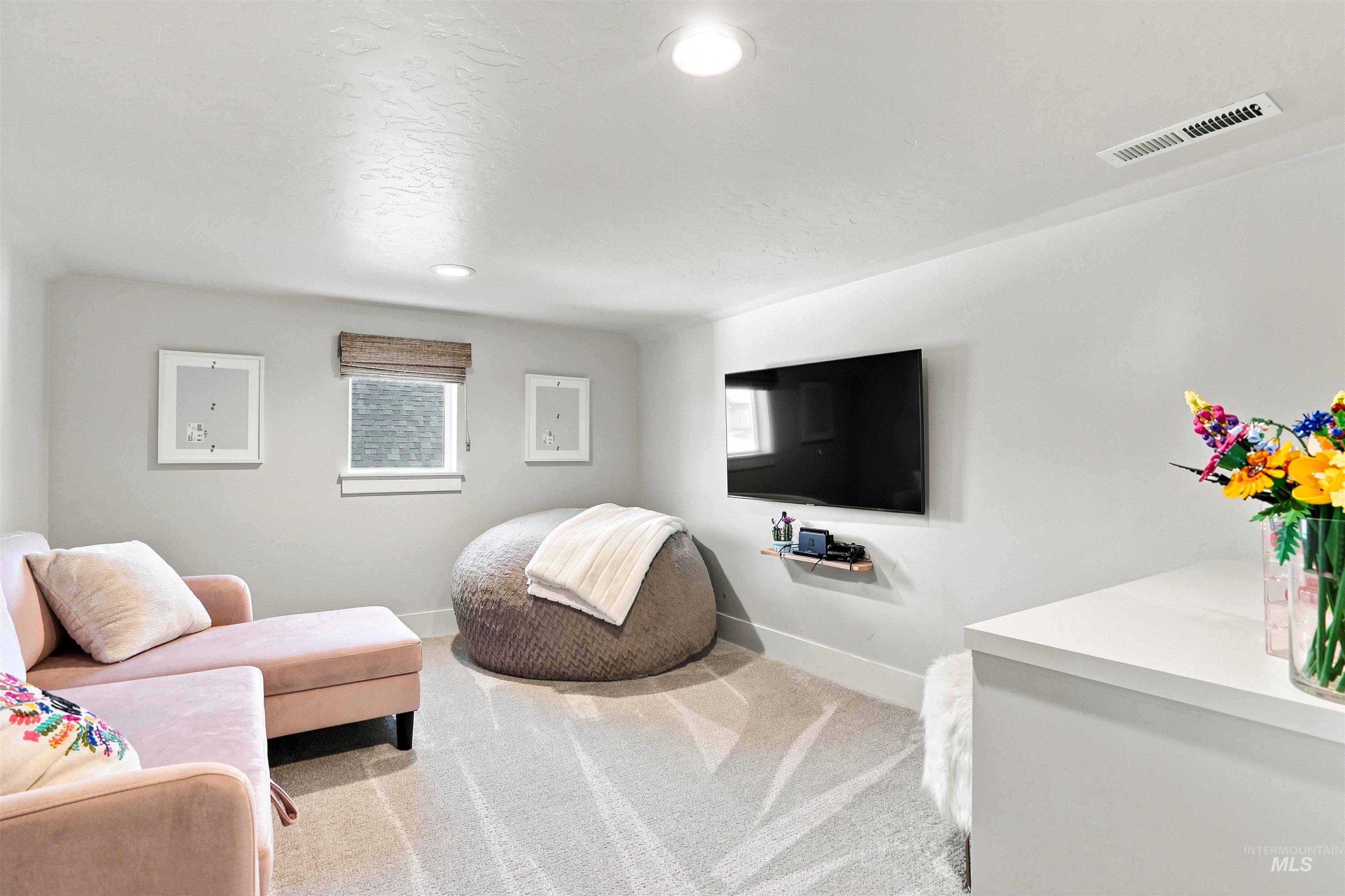 4323 West Ladle Rpds Drive Meridian, ID 83646 - Photo 31 of 49 Neutral-toned room featuring a single window with a woven Roman shade, recessed lighting, and light-colored patterned carpeting