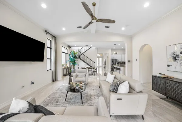 a living room with furniture a flat screen tv and a large window
