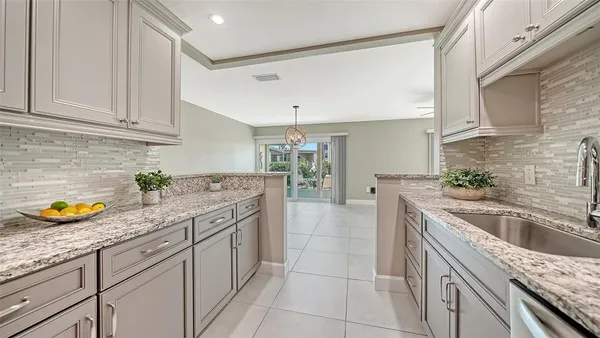 an empty room with a window and a chandelier fan