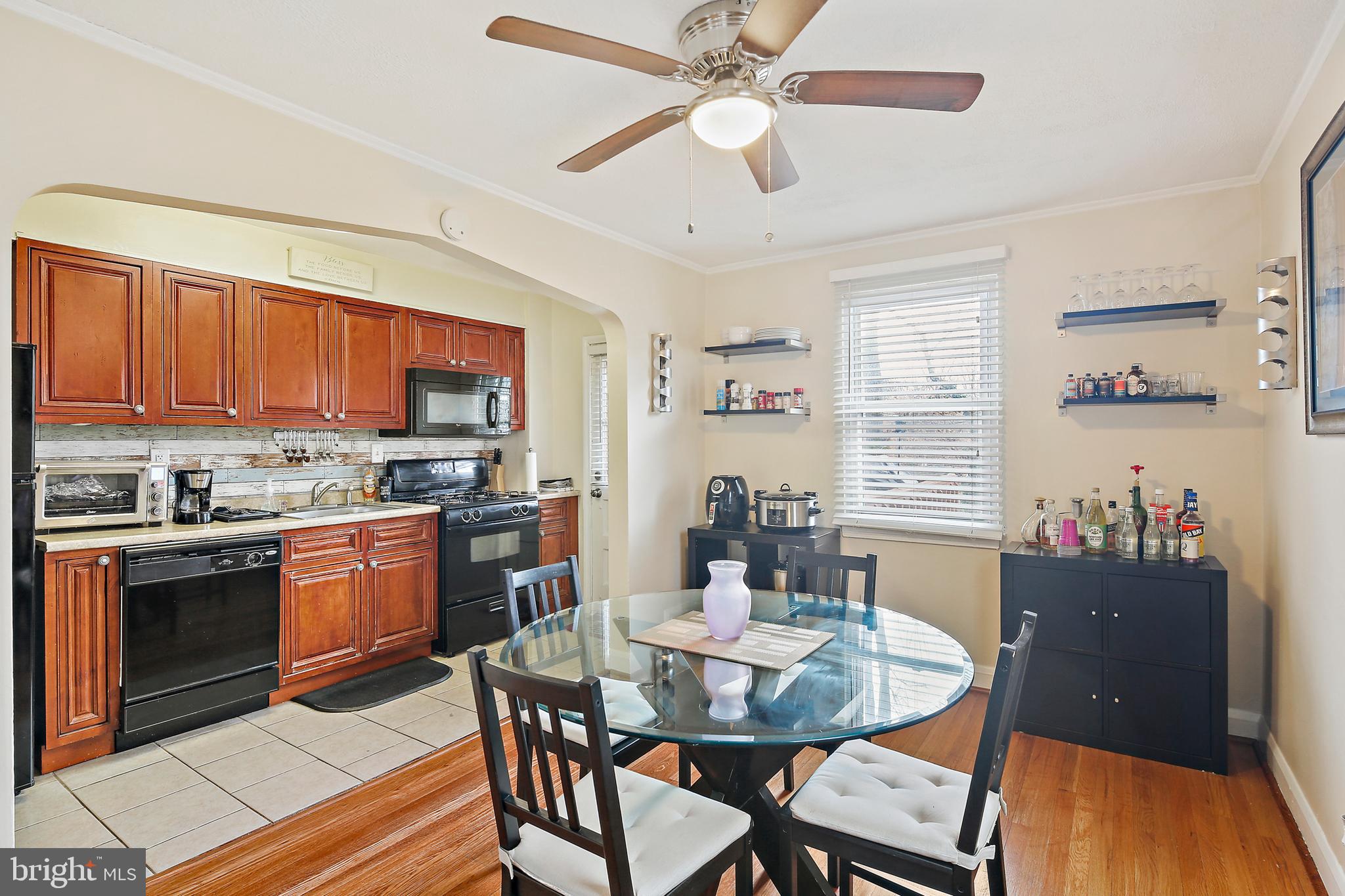 a kitchen with a dining table chairs stainless steel appliances and cabinets