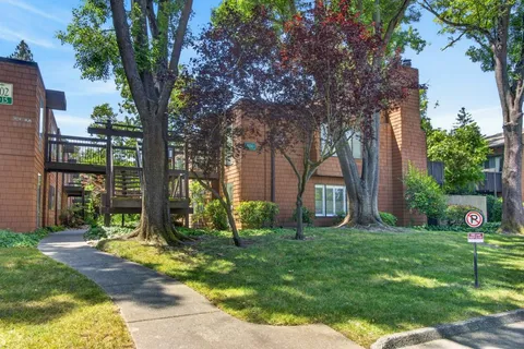 a view of a house with backyard and a tree