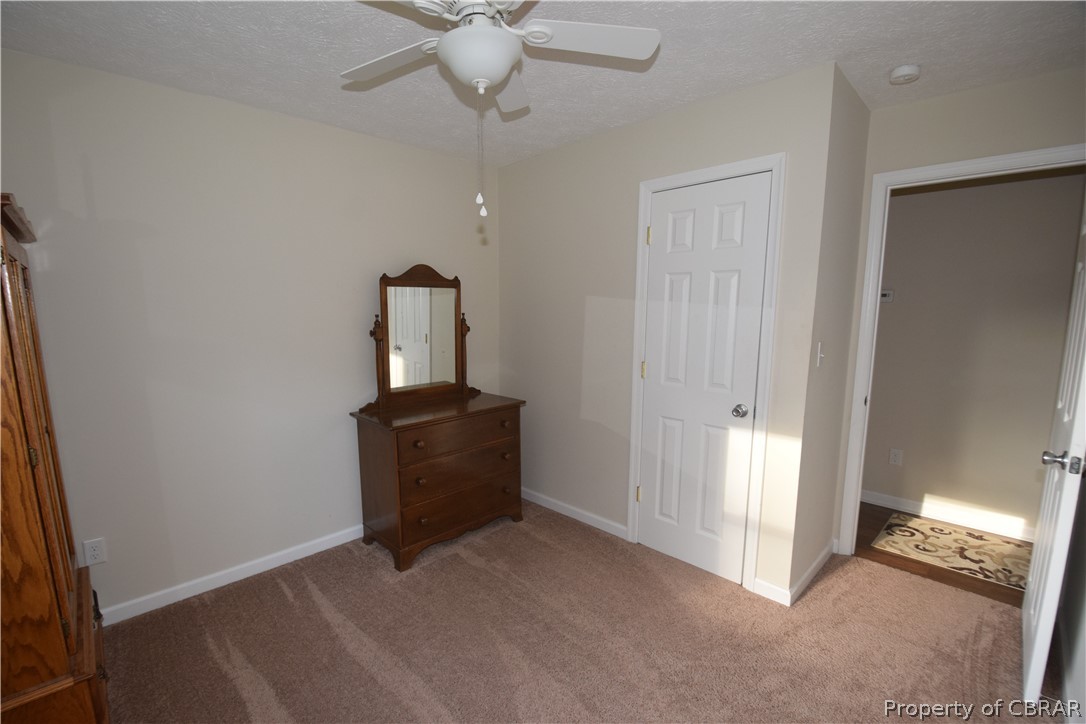 561 Possum Point Road Port Haywood, VA 23138 - Photo 16 of 23 en empty room with windows and ceiling fan