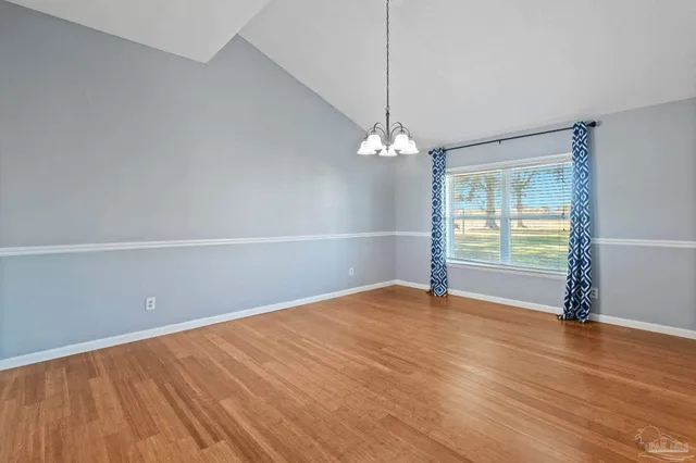 a view of wooden floor chandelier and window in a room