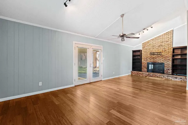 a view of an empty room with a fireplace and a window