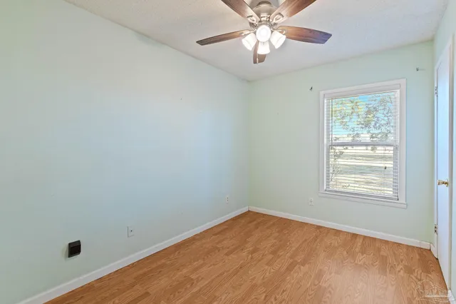 an empty room with a window and wooden floor