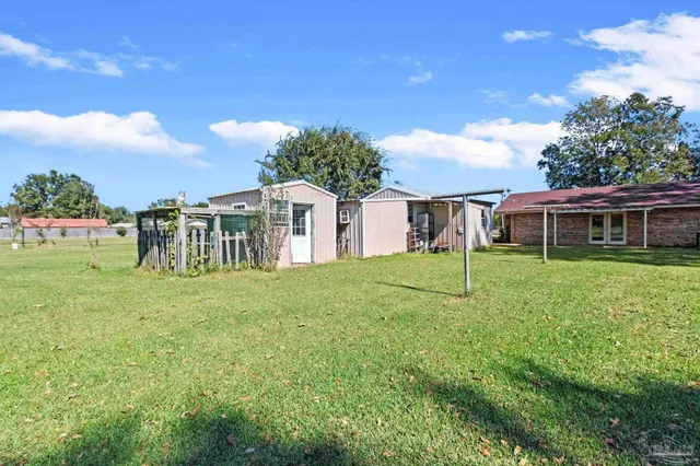 a view of a house with a big yard with large trees