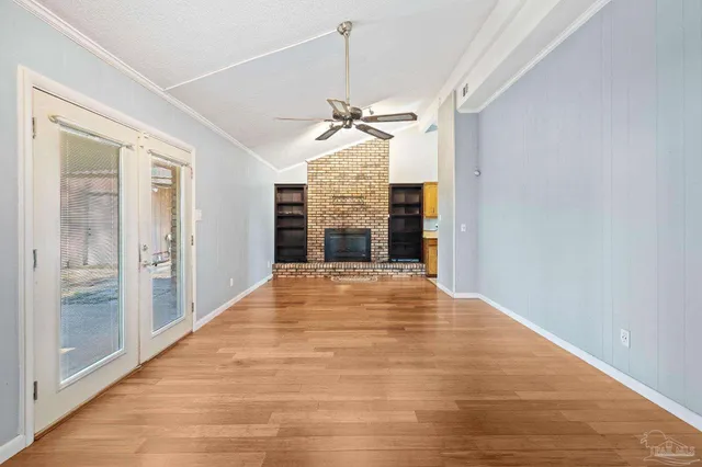 a view of a room with a ceiling fan and entryway