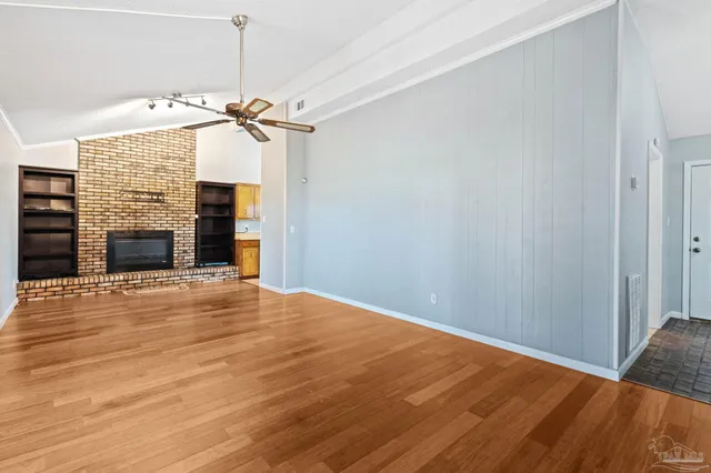 a view of a livingroom with a fireplace and a ceiling fan