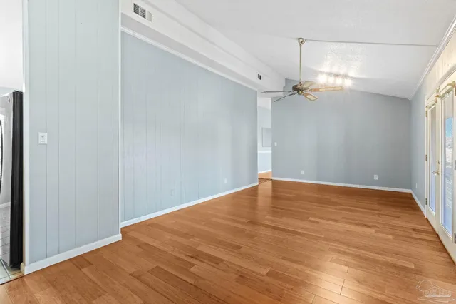 a view of empty room with wooden floor