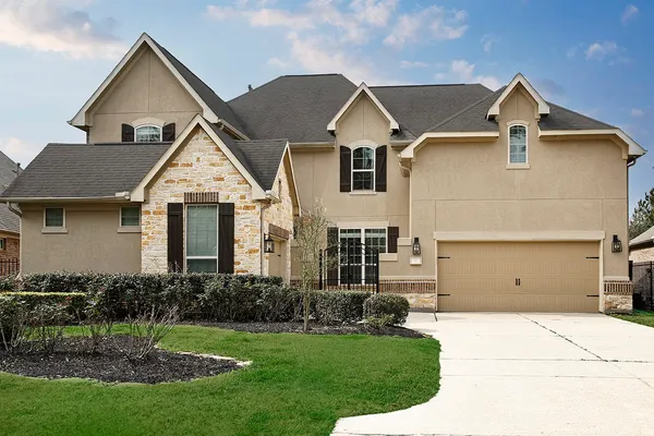 a front view of a house with a yard and garage