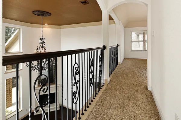 a view of a hallway with wooden floor and staircase