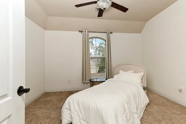 a bedroom with a bed and a window