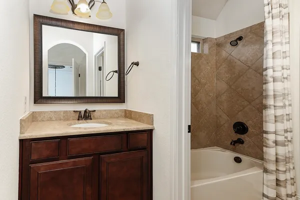 a bathroom with a bathtub sink and mirror