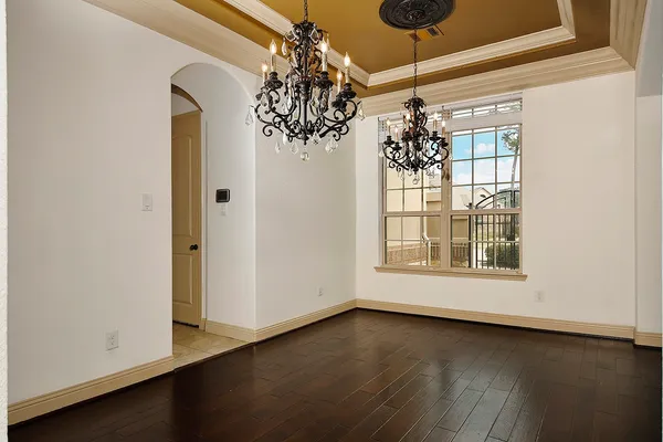a view of a room with wooden floor and chandelier