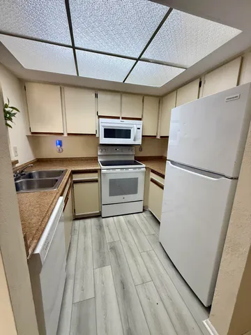 a kitchen with wooden cabinets and white appliances