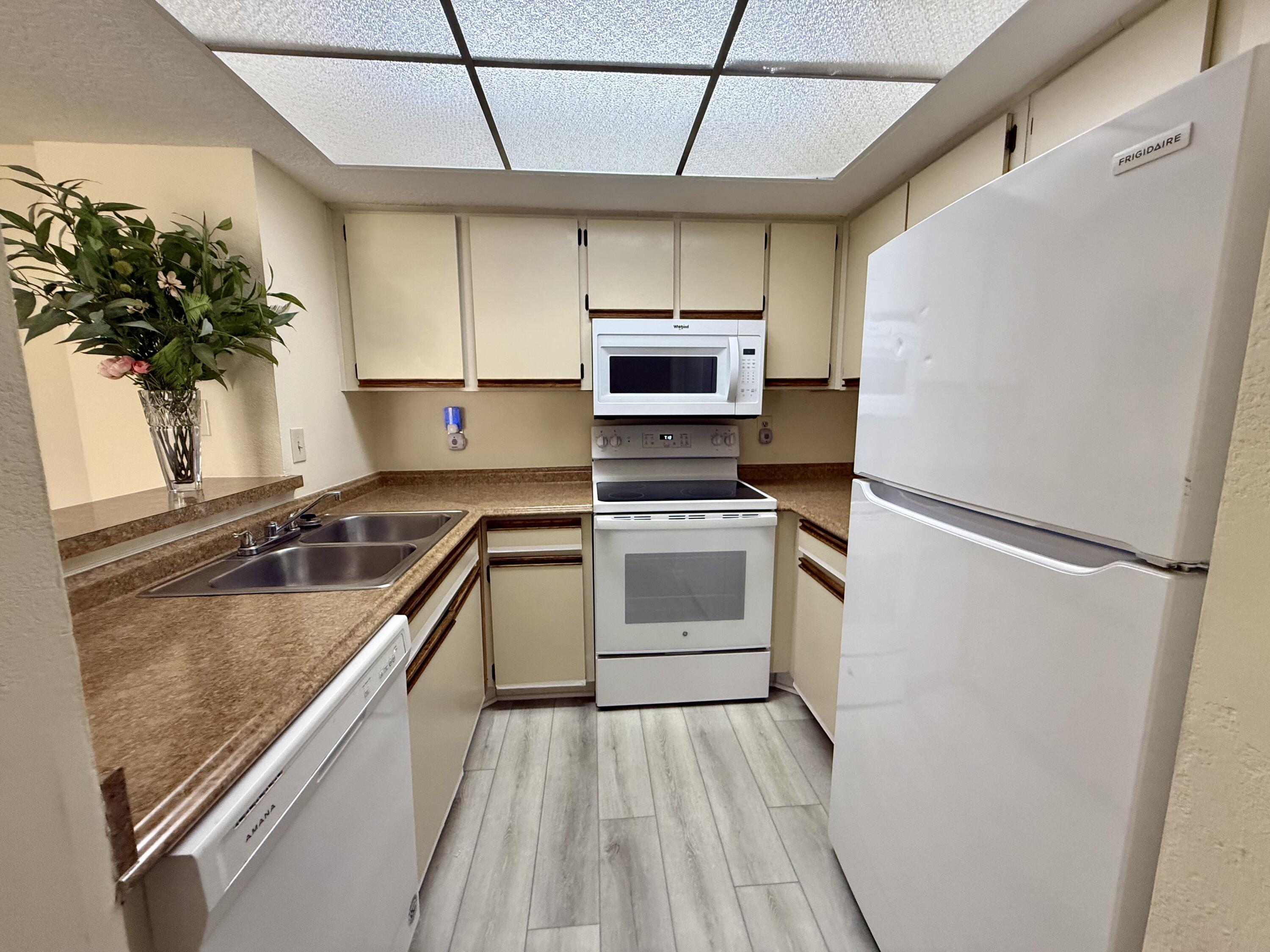 1520 Southeast Royal Green Circle, Unit K 205 Port St. Lucie, FL 34952 - Photo 15 of 18 a kitchen with a sink appliances and cabinets