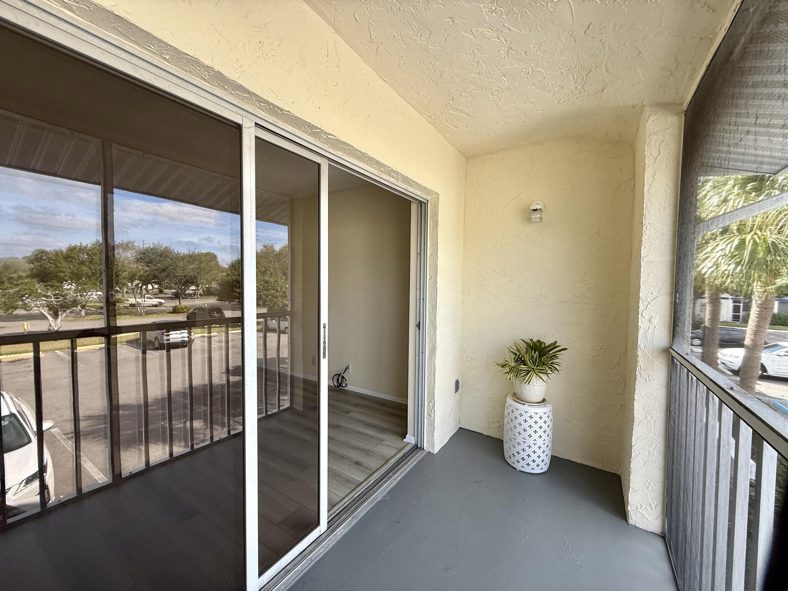 1520 Southeast Royal Green Circle, Unit K 205 Port St. Lucie, FL 34952 - Photo 16 of 18 a view of empty room with floor to ceiling window and wooden floor