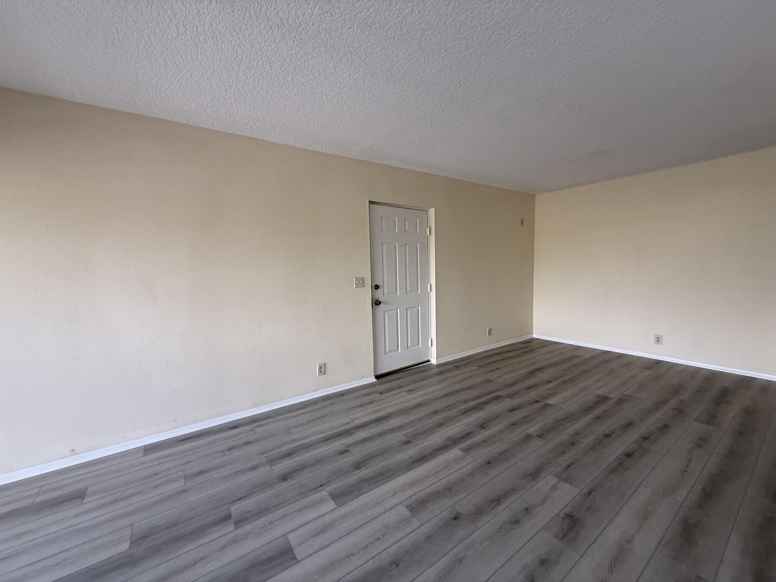 1520 Southeast Royal Green Circle, Unit K 205 Port St. Lucie, FL 34952 - Photo 3 of 18 a view of an empty room with wooden floor