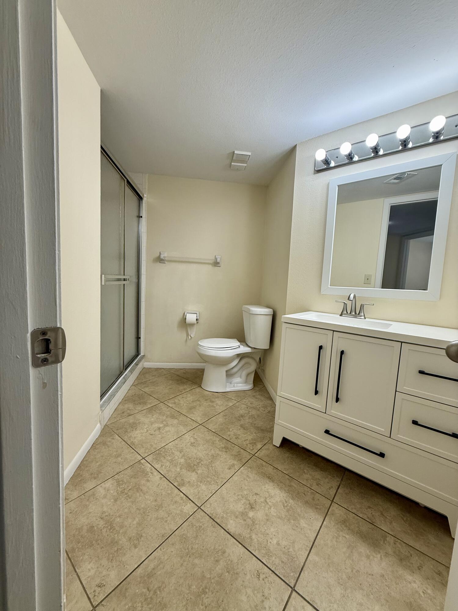 1520 Southeast Royal Green Circle, Unit K 205 Port St. Lucie, FL 34952 - Photo 7 of 18 a bathroom with a toilet sink and mirror