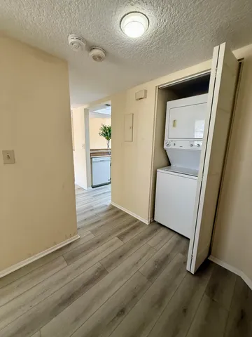 a view of a hallway with wooden floor and a cabinet