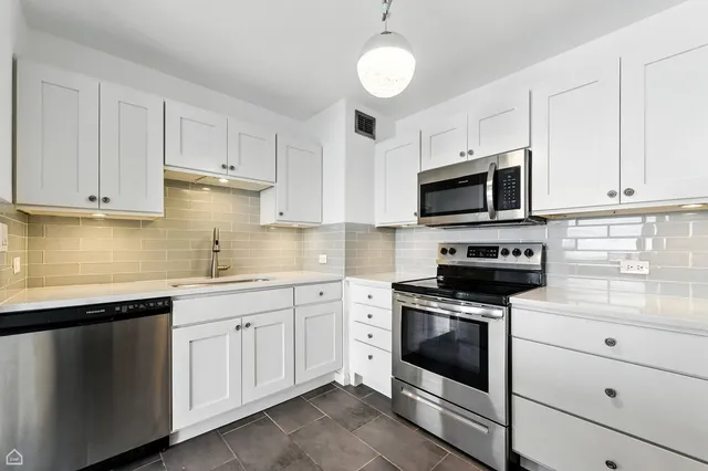 a kitchen with cabinets stainless steel appliances a sink and a counter space