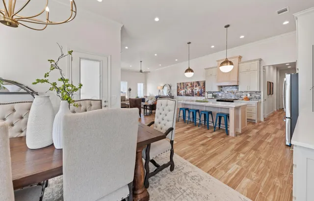 a living room with furniture kitchen view and a chandelier