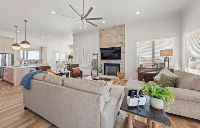 a living room with furniture potted plant and kitchen view