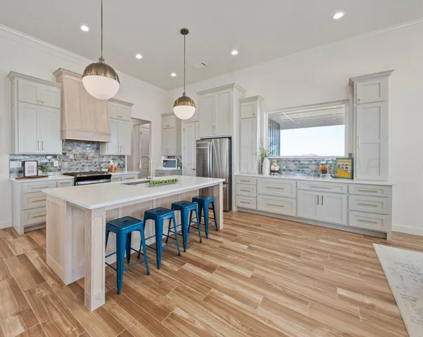 a kitchen with stainless steel appliances kitchen island a large island in the center and wooden floors