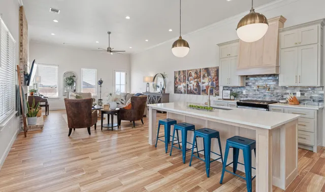 a large kitchen with lots of furniture a sink appliances and dining table