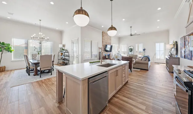 a large kitchen with cabinets a sink a counter space and stainless steel appliances