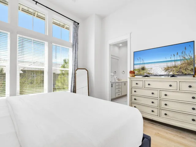 a large bed sitting in a bedroom next to a window