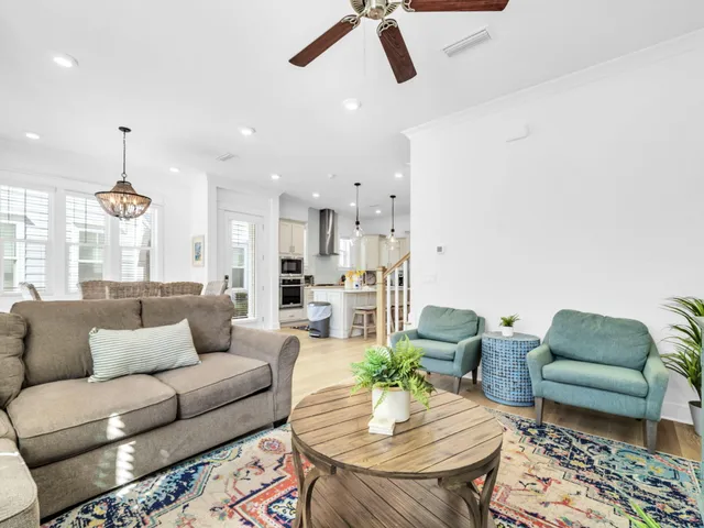 a living room with furniture and a dining table with kitchen view