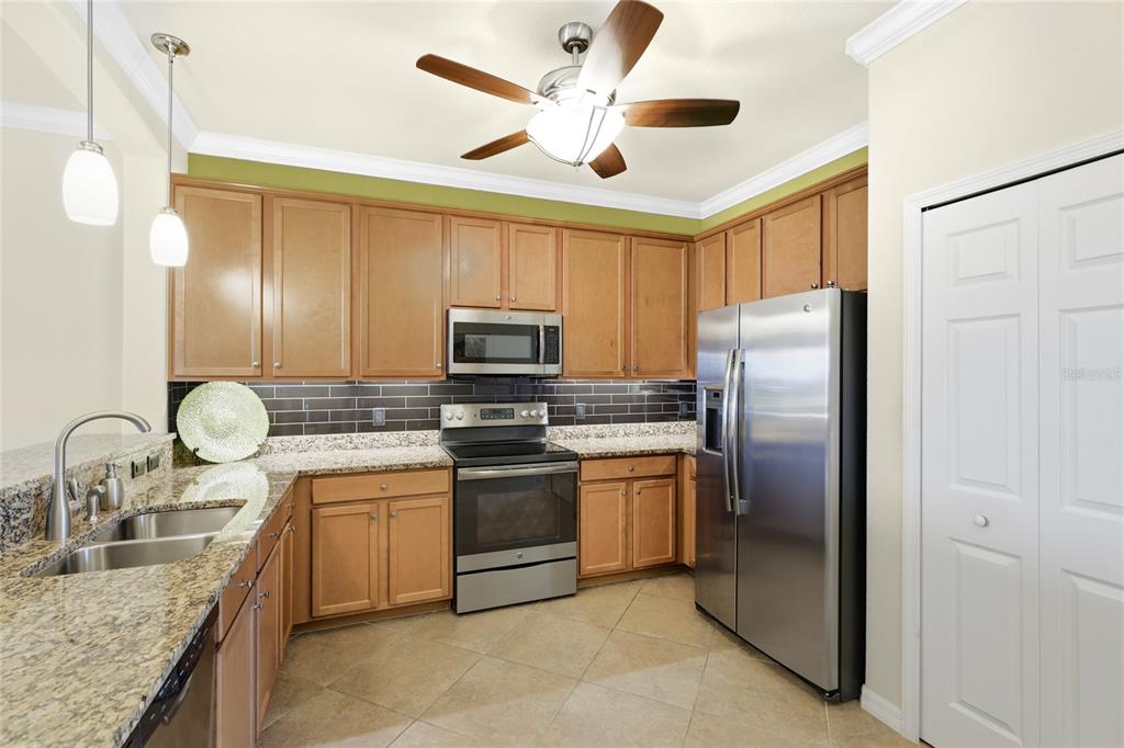 20209 Benissimo Drive Venice, FL 34293 - Photo 5 of 53 a kitchen with stainless steel appliances granite countertop a sink a stove and a refrigerator