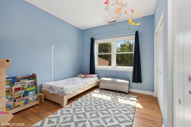 a bedroom with a bed and wooden floor