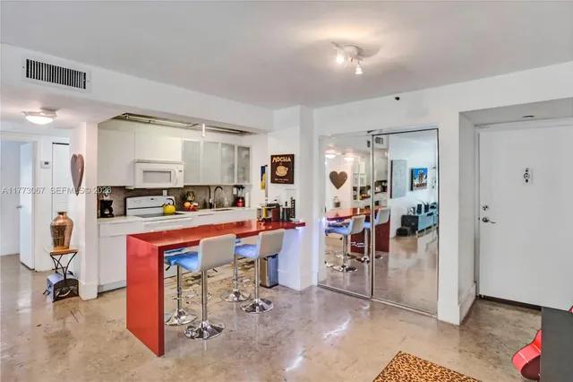 a view of a kitchen with dining area refrigerator and wooden floor