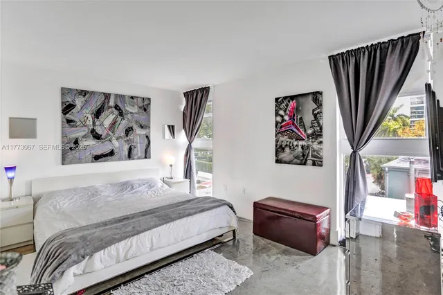 a bedroom with a bed and a painting on the wall