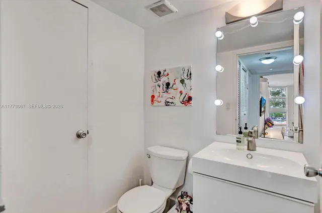 a bathroom with a sink mirror and toilet