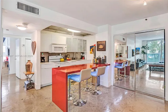 a living room with stainless steel appliances kitchen island granite countertop furniture and a view of kitchen