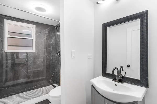 a bathroom with a sink a toilet and shower