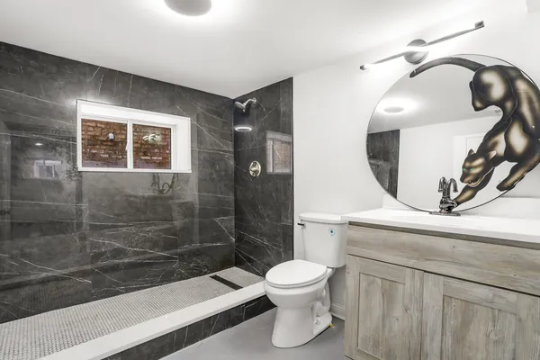 a bathroom with a toilet a sink and mirror