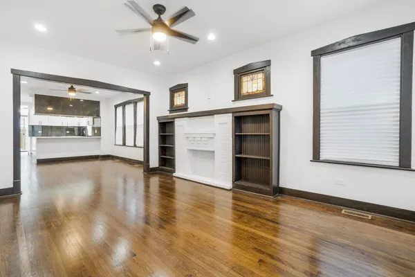 a view of an empty room with a window and wooden floor