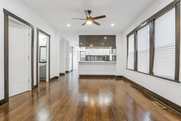 a view of a livingroom with wooden floor and a ceiling fan