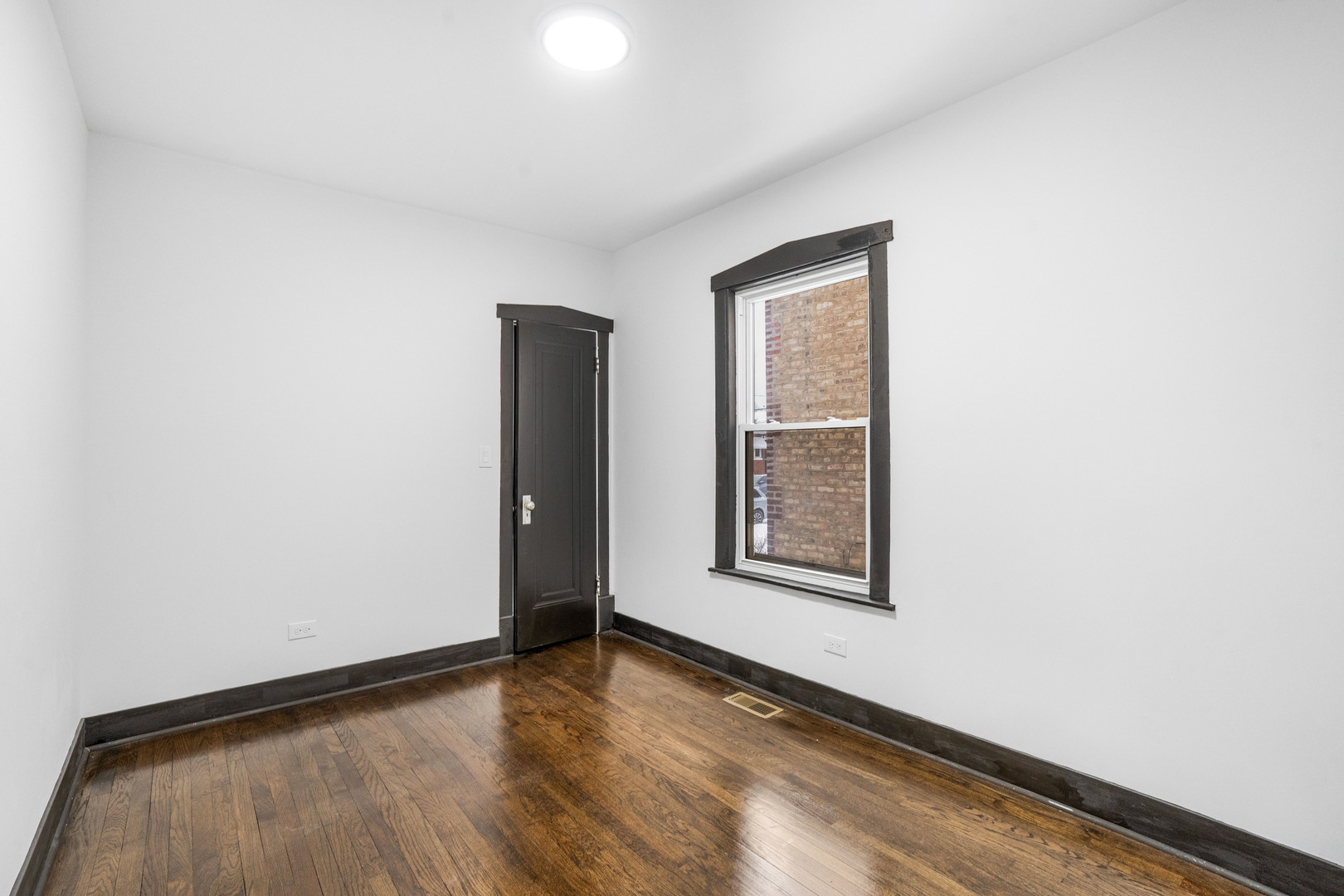 5526 South Albany Avenue Chicago, IL 60629 - Photo 9 of 25 an empty room with wooden floor and windows