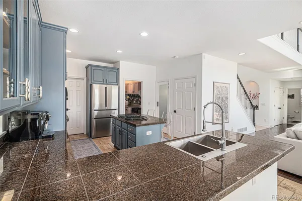 a kitchen with stainless steel appliances granite countertop a sink stove and refrigerator