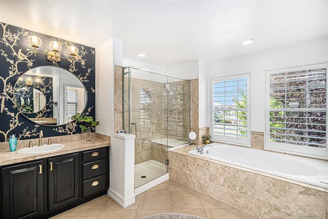 a spacious bathroom with a tub sink and mirror